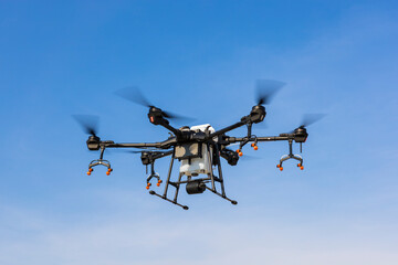Fototapeta premium Agriculture drone flying in the blue sky