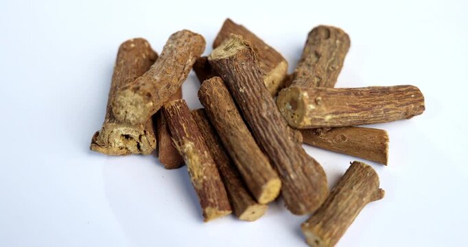 Ayurvedic Mulethi or Liquorice root stick or jeshthamadh powder served in a bowl over moody background