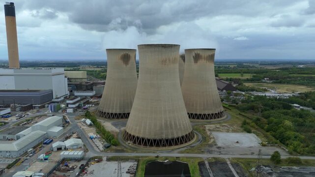 Aerial drone view of Huge power plant with colling towers and smoke plumes billowing, industrial energy electrical generation coal gas and oil near Selby, Yorkshire, United Kingdom