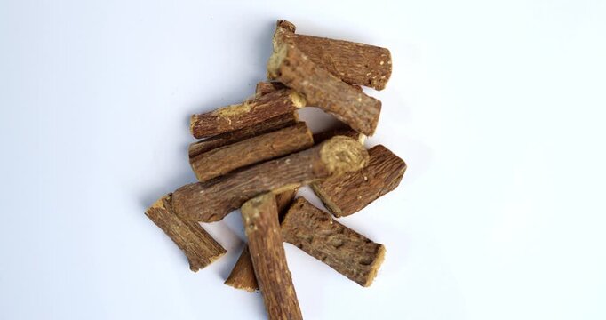 Ayurvedic Mulethi or Liquorice root stick or jeshthamadh powder served in a bowl over moody background