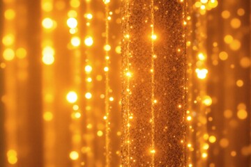 Brilliant gold bokeh lights shimmer vertically against a glittering textured surface background