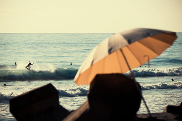 Relaxing beach perspective with active surfer on a wave