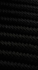 Detailed macro shot showing the fine woven texture of modern black carbon fiber material used in advanced engineering and manufacturing processes ,modern ,advanced ,lightweight