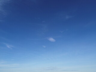 Obraz premium Minimalist sky background with soft cirrus clouds on a bright blue sky. Clean atmospheric texture ideal for design and backgrounds.