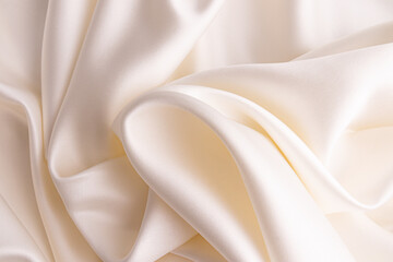 chic voluminous pleats of delicate cream-colored satin fabric. Wedding background for design....