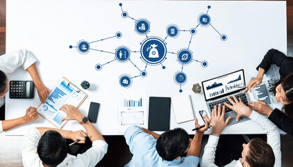 A modern office scene showing a dynamic business meeting with professionals analyzing data on laptops and tablets, surrounded by charts and graphs for strategic planning. Amity