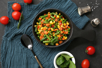 Frying pan with tasty roasted vegetables on black background