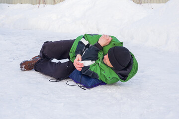 A man fell on slippery ice in winter.