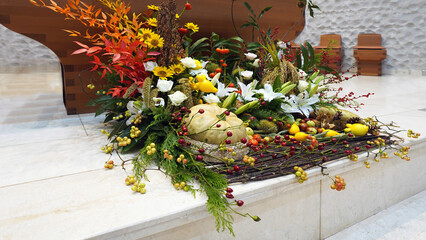 Autumn church flower decoration featuring pumpkins, berries, and fall foliage