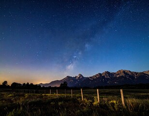 Mountain range below dark, starry night sky