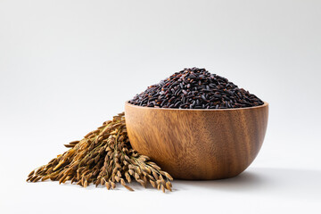 Black rice is in a wooden bowl, with some ears of rice placed beside it.