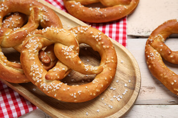 Tray with tasty pretzels on white wooden background, closeup