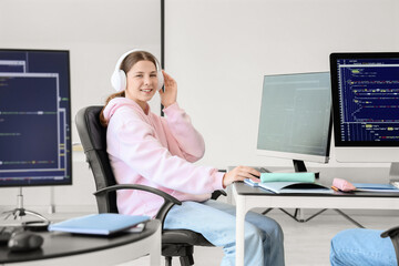Female student in headphones studying at school computer lab