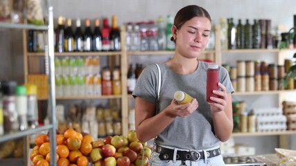 Young woman choosing natural smoothies in supermarket. European woman came to the store for natural smoothies without sugar for her healthy breakfast. High quality 4k footage