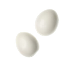 Flying boiled chicken eggs on white background