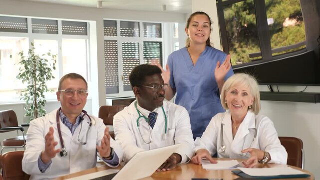  In conference room, doctors pose after successful meeting for final report. Snapshot of positive prosperous clinic staff for social networks and promotion of clinic sales