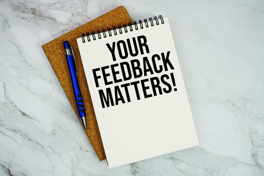 Your Feedback Matters! text written on notepad with pen on marble background