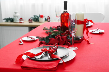 Beautiful Christmas table setting with fir tree branches and berries in living room, closeup