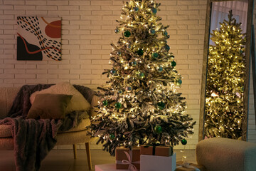 Comfortable sofa, Christmas tree, floor mirror and pouf in interior of dark living room