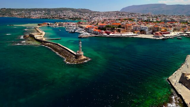Discover the stunning views of Chania harbor in Crete, featuring a charming lighthouse and vibrant waterfront buildings. The clear blue waters enhance the scenic beauty.