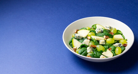 Salad with spinach, blue cheese, pear, grapes, and nuts. Healthy eating. Vegetarian.