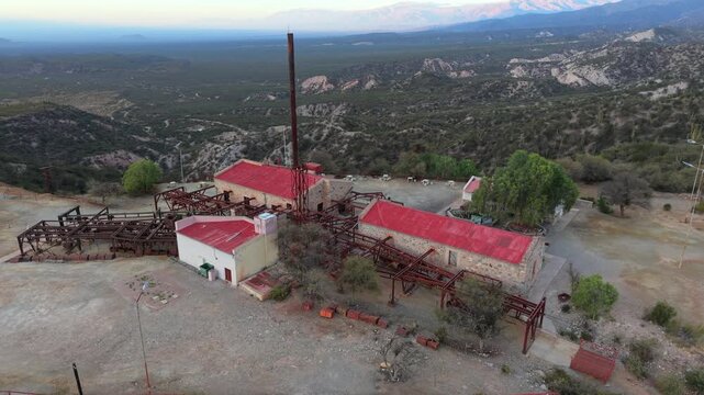 Historic hotel and mining ruins of Estaci&oacute;n 2 Cable Carril with red roofs and tall chimney in the mountains, Chilecito, La Rioja, Argentina.
