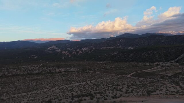 Avenida la Mexicana winds through dry hills and the Chilecito valley, with the Andes on the horizon in La Rioja Province, Argentina.