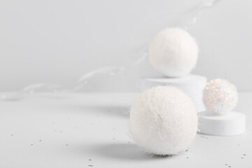 Composition with Christmas balls and plaster podiums on white background, closeup