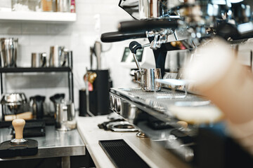 Coffee preparation station in a modern cafe with stainless steel equipment and tools