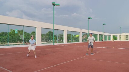 Asian sportsman and woman playing tennis match on outdoor clay court - Powered by Adobe