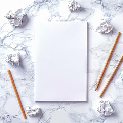 A blank white sheet of paper is surrounded by crumpled paper balls and pencils on a bright, marble-patterned surface. Overhead view with soft, natural lighting.