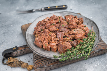 Tender slow cooked venison moose stew served on a grey plate with rustic texture, showcasing juicy shredded game meat and rich braised flavor.