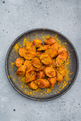 Traditional currywurst sprinkled with curry spice on textured surface great for German street food concepts and culinary stock content.