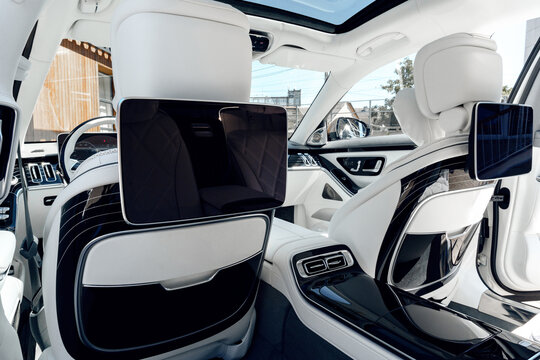 Luxury car interior showcasing advanced entertainment screens and spacious seating design