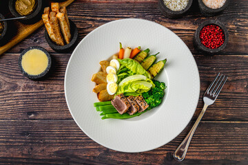 Fresh tuna salad with vegetables, eggs, and green greens