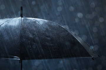 Closeup of black umbrella in the rain