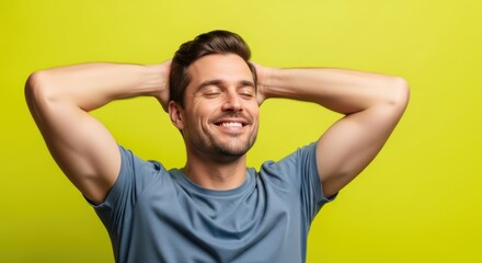Happy caucasian young adult male relaxing with hands behind head on green background