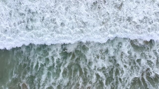 Ocean waves crashing strongly. Sea water swirling on coast. Ocean movement near shoreline. Sea waves pushing to land. Ocean foam spreading on sand. Sea waves rising and falling.
