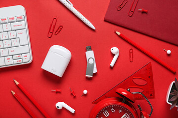 Composition with keyboard, stationery and modern flash drive on red background