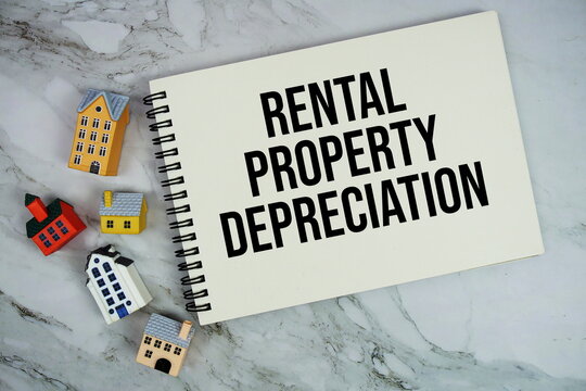 Rental Property Depreciation text written on notepad with house model on marble background