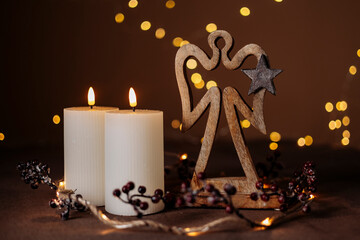 Fototapeta premium Advent white candles with decor in shiny lights closeup