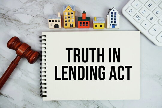 TILA Truth In Lending Act text written on notepad with house model, calculator and gavel on marble background