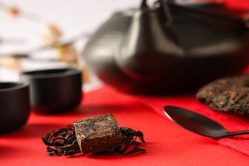 Dry pressed puer tea with cups and spoon on color background