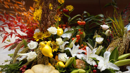 Colorful Thanksgiving centerpiece featuring chrysanthemums, gourds, and autumn fruits