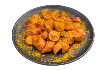 Traditional currywurst sprinkled with curry powder on black dish great for German street food concepts and high quality food photos.