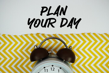 Plan Your Daytext written on paper with alarm clock on yellow chevron background