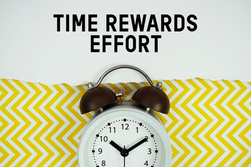 Time Rewards Effort text written on paper with alarm clock on yellow chevron background