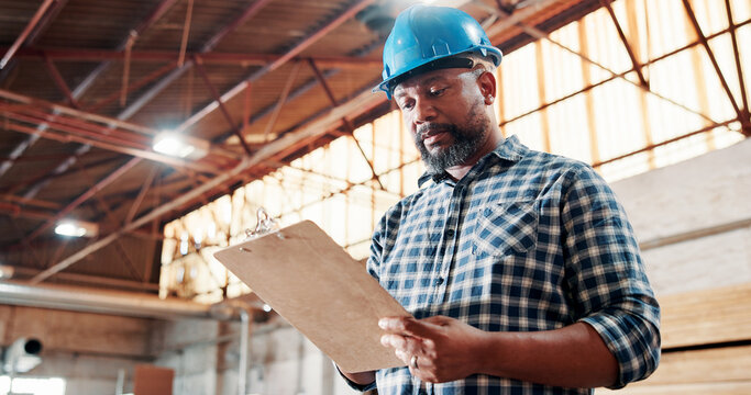 Black man, carpenter and clipboard with checklist for woodwork, project or inventory in warehouse. Male person, carpentry or list in furniture business for wood construction or stock check in depot