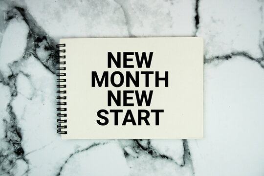 New Month New Start  text written on notepad flat lay on marble background