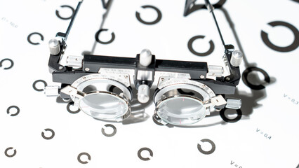 A device for measuring vision, recommendations for eye care. Test frame, optometric test frame for vision testing. Vision check, test-rimmed glasses. Optical reading glasses on the examination table